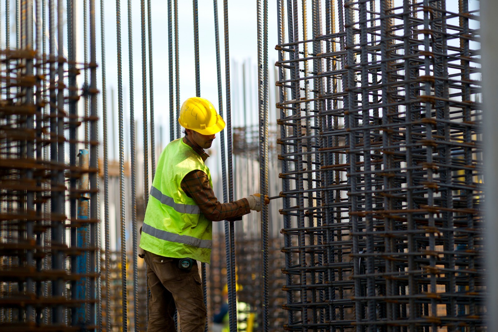 Steel fixer placing rebar reinforcement on a construction site